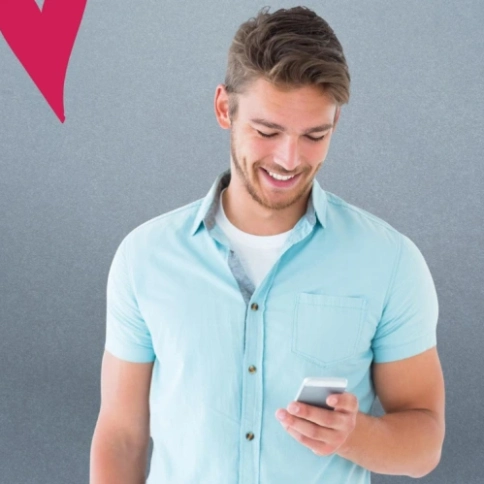 Ein Mann lacht über sein Handy, im Hintergrund sind Herzen zu sehen.