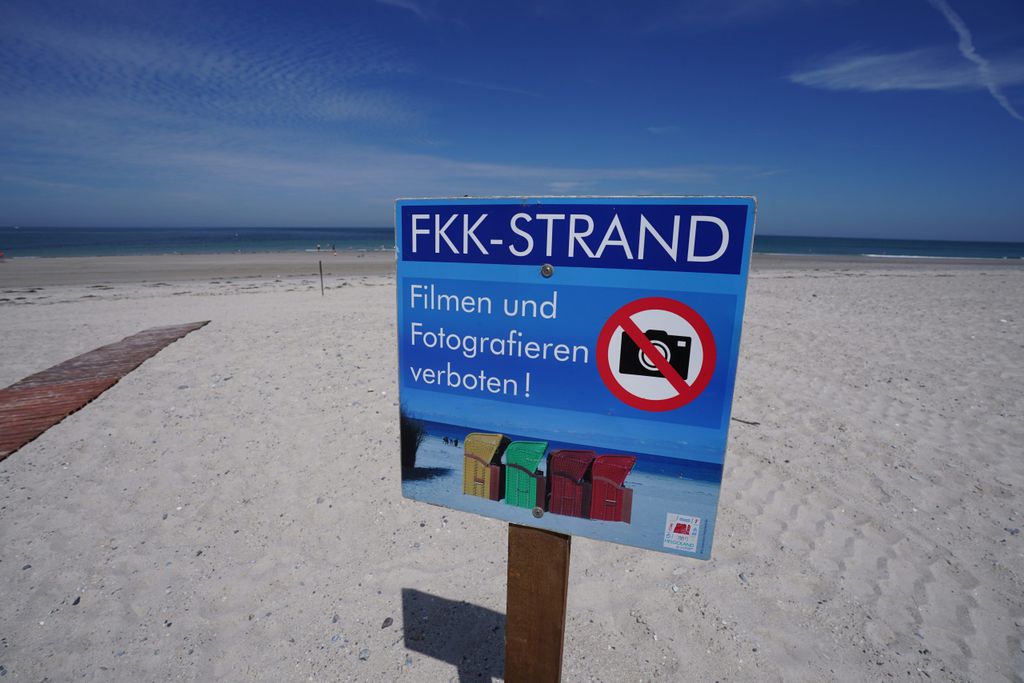 Schleswig-Holstein, Helgoland: Ein Hinweisschild mit der Aufschrift "FKK-Strand. Filmen und Fotografieren verboten!" steht am FKK-Strand auf der Düne der Hochseeinsel Helgoland.