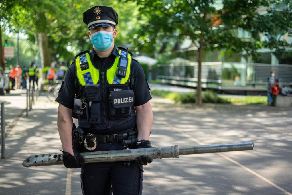 Ein Polizist hält den Bohrkopf in der Hand. Dieser hatte sich in die Bahn gebohrt.