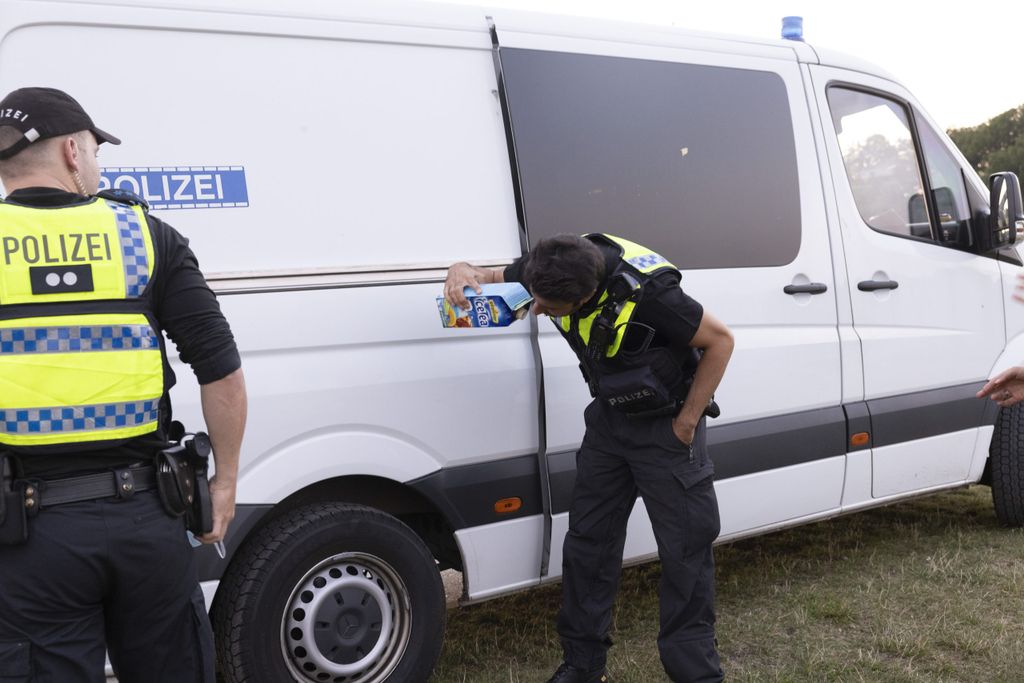 Polizeibeamter riecht an einer Eistee-Packung. Er stellt Alkoholgeruch fest.