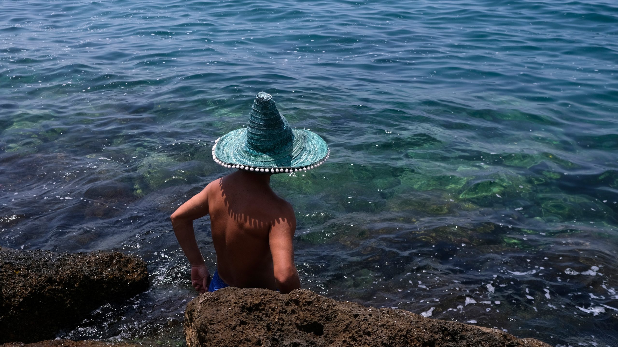 Ein Mann kühlt sich bei Athen im Meer ab.