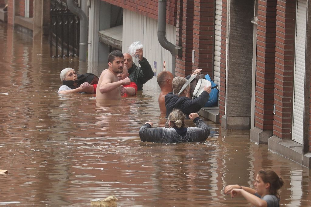 Menschen waten durch das Wasser, das ihnen teilweise bis zum Hals reicht