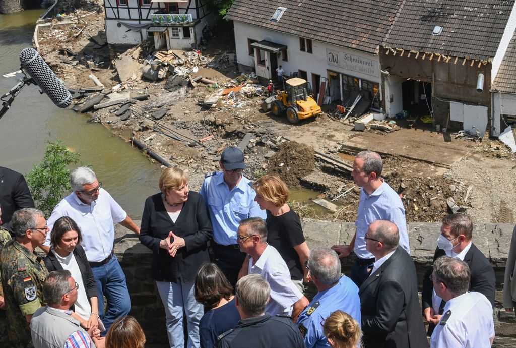 Bundeskanzlerin Angela Merkel (4.v.l.) und Malu Dreyer (5.v.l,SPD), Ministerpräsidentin von Rheinland-Pfalz, stehen während ihres Besuchs in den vom Hochwasser betroffenen Gebieten auf einer Brücke, um die Schäden zu begutachten und mit Betroffenen zu sprechen.