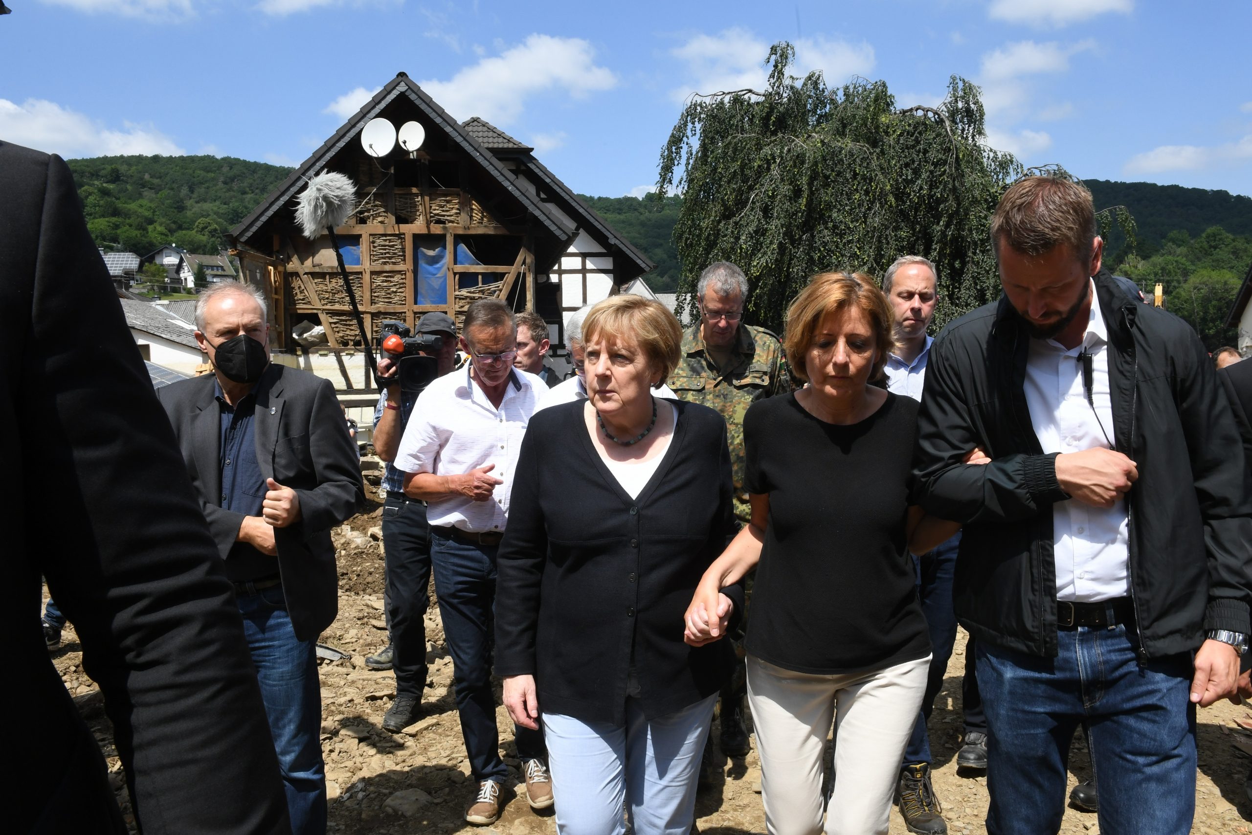 Bundeskanzlerin Angela Merkel (3.v.r.) und Malu Dreyer (2.v.r,SPD), Ministerpräsidentin von Rheinland-Pfalz, gehen durch das vom Hochwasser verwüstete Dorf Schuld in der Nähe von Bad Neuenahr-Ahrweiler