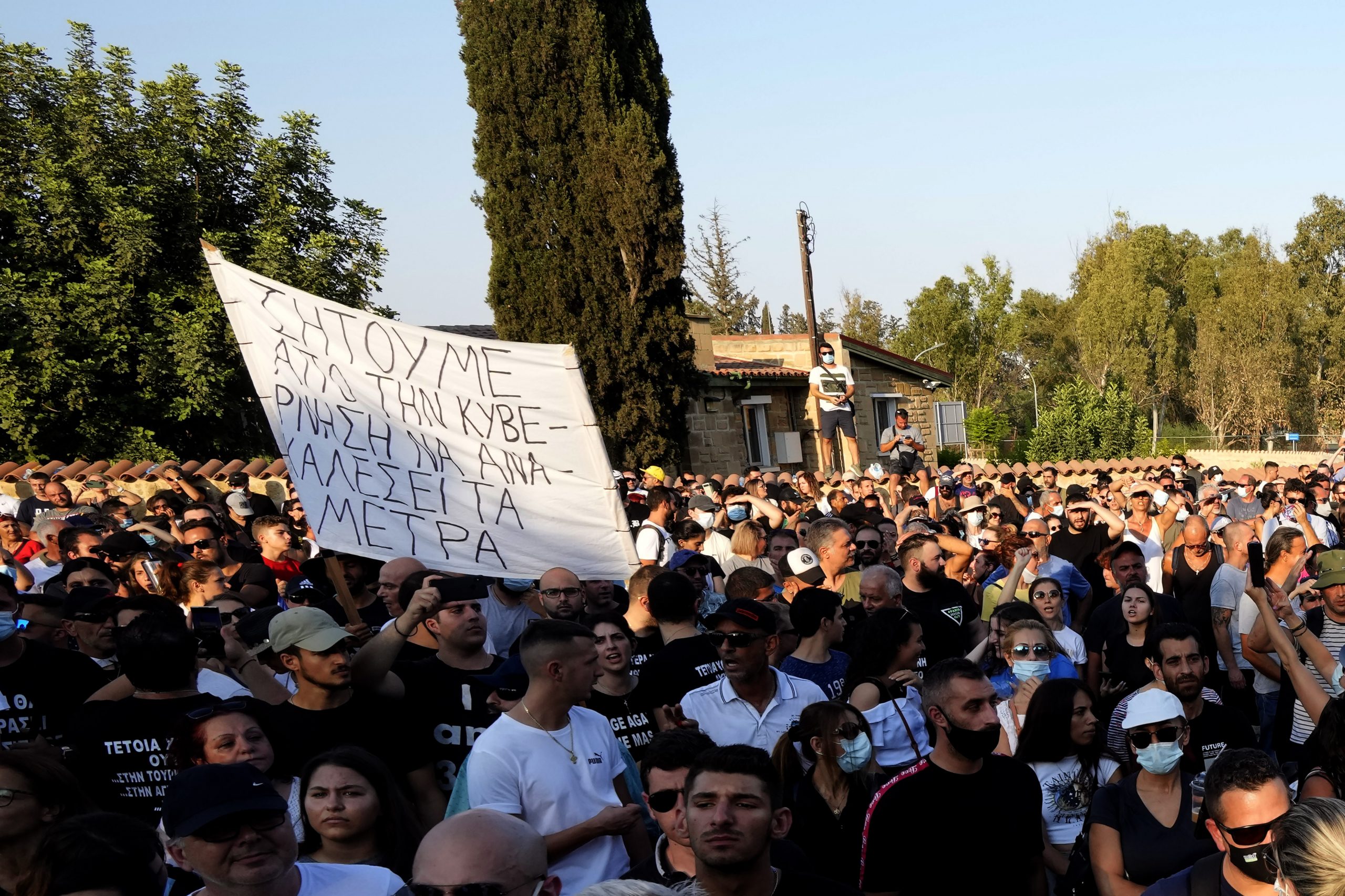 Demonstranten halten ein Transparent, auf dem auf Griechisch steht: „Wir fordern die Regierung auf, die Maßnahmen zurückzunehmen“, während eines Protests gegen die Corona-Maßnahmen der Regierung vor dem Präsidentenpalast.