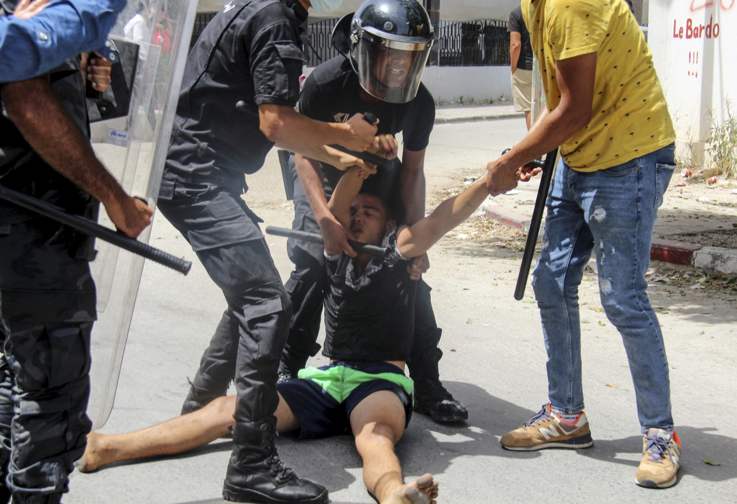 Polizisten halten einen Demonstranten in Tunesien gewaltsam fest.