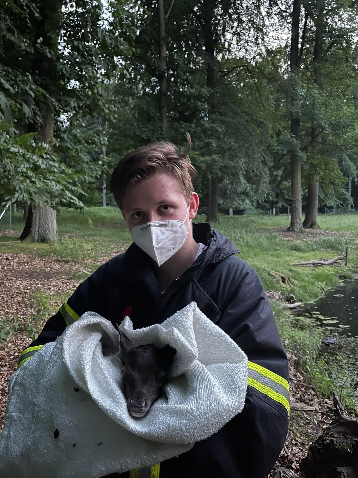 Konstantin Pistorius von der Freiwilligen Feuerwehr Nienstedten mit dem geretteten Hirschkalb.