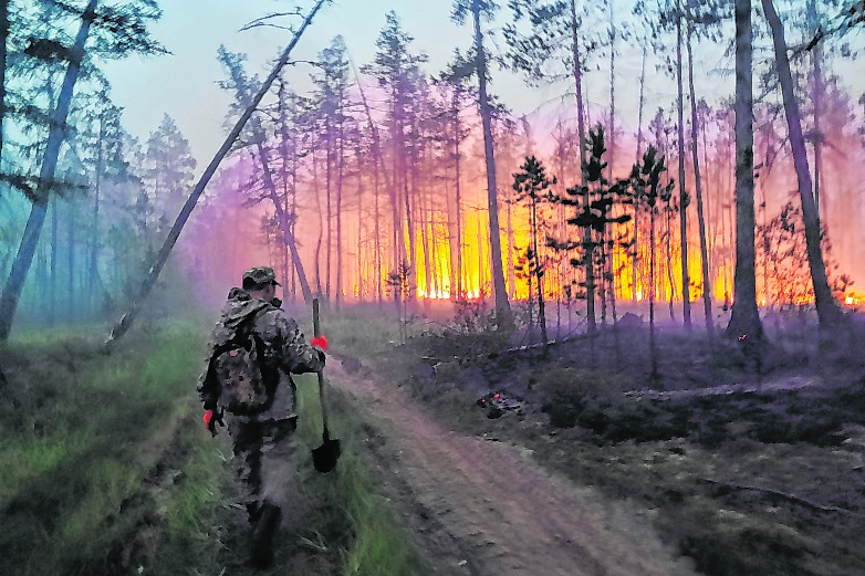 Ein Soldat geht auf einen Waldbrand in Russland zu