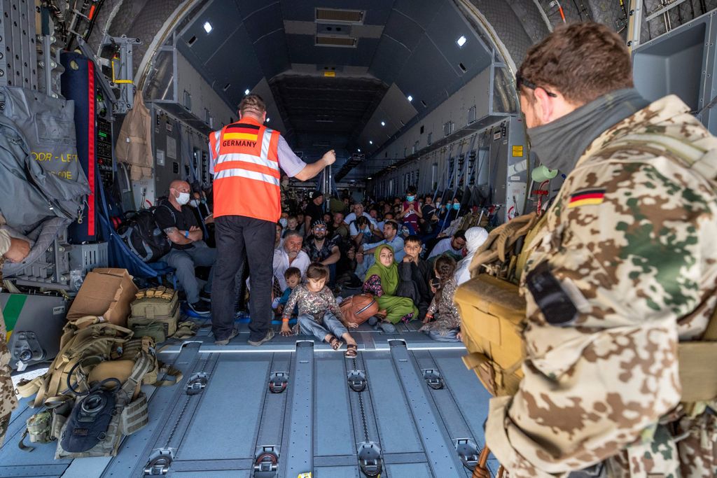 Menschen sitzen auf dem Boden eines Militärflugzeugs