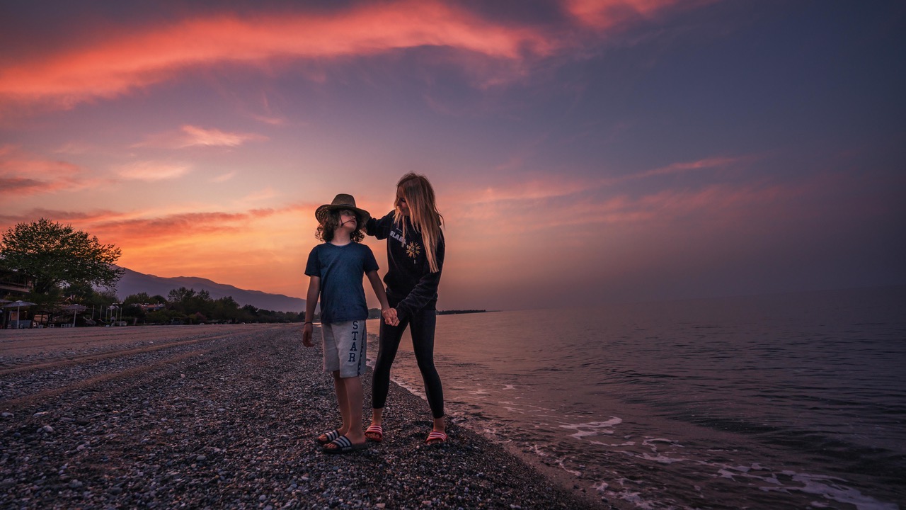 Mateo und Tanja Howe stehen während eines Sonnenunterganges an einem Strand.