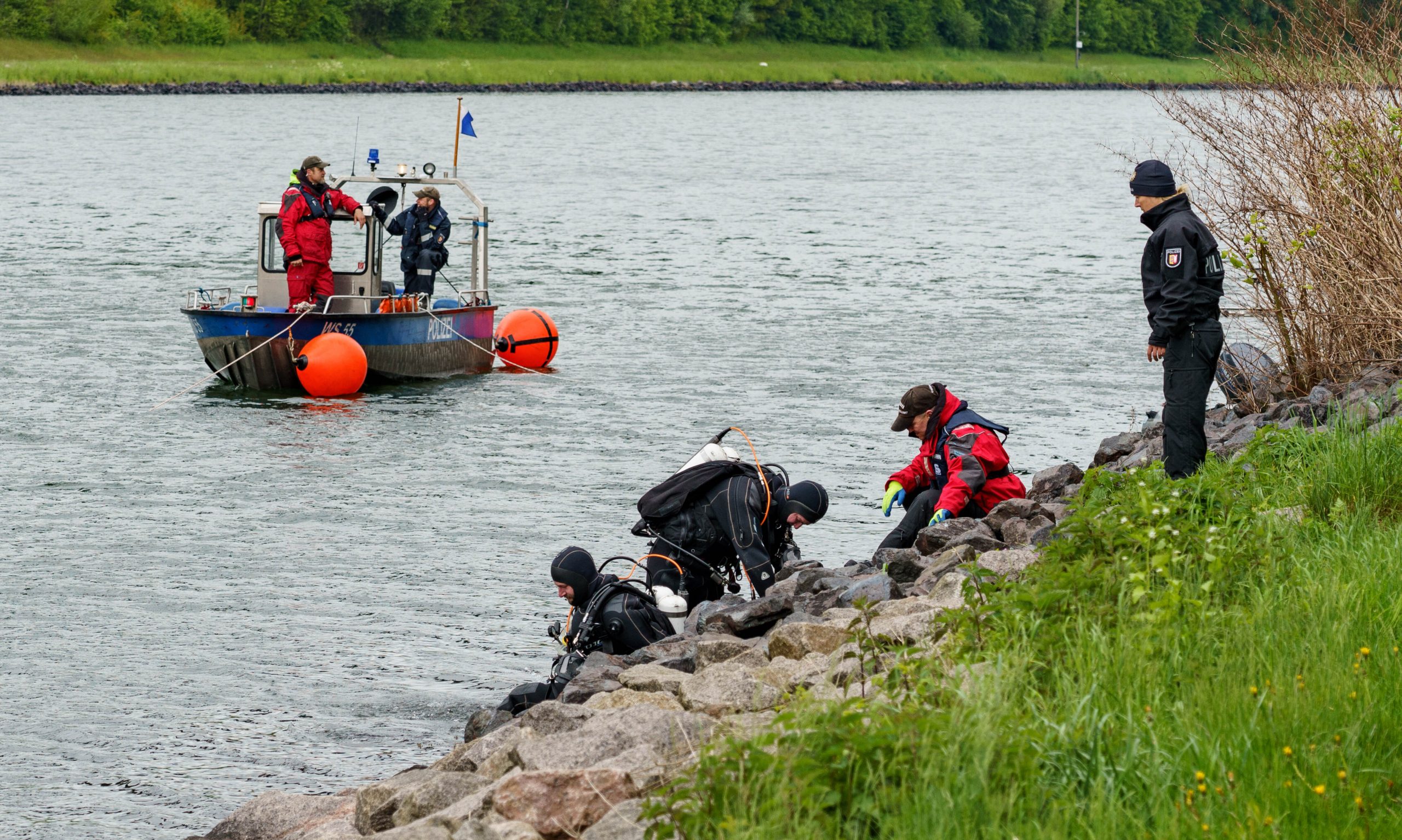 Taucher der Polizei steigen in den Nord-Ostseekanal ein.