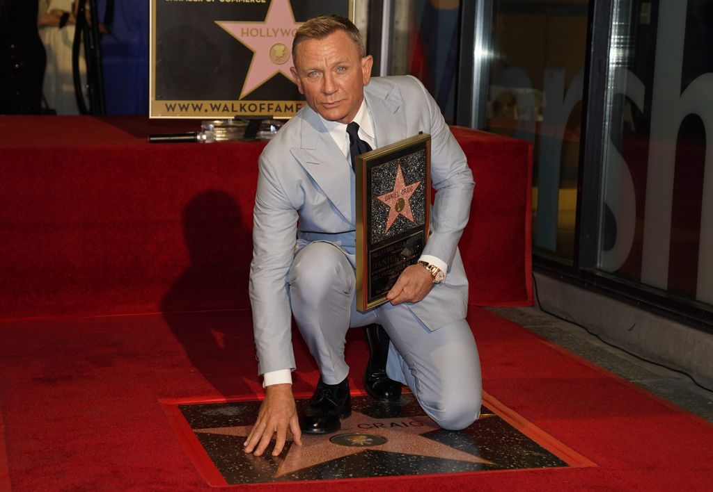 Daniel Craig posiert auf seinem neuen Stern auf dem Hollywood Walk of Fame, während er eine Nachbildung des Sterns während einer Zeremonie zu seinen Ehren hält.