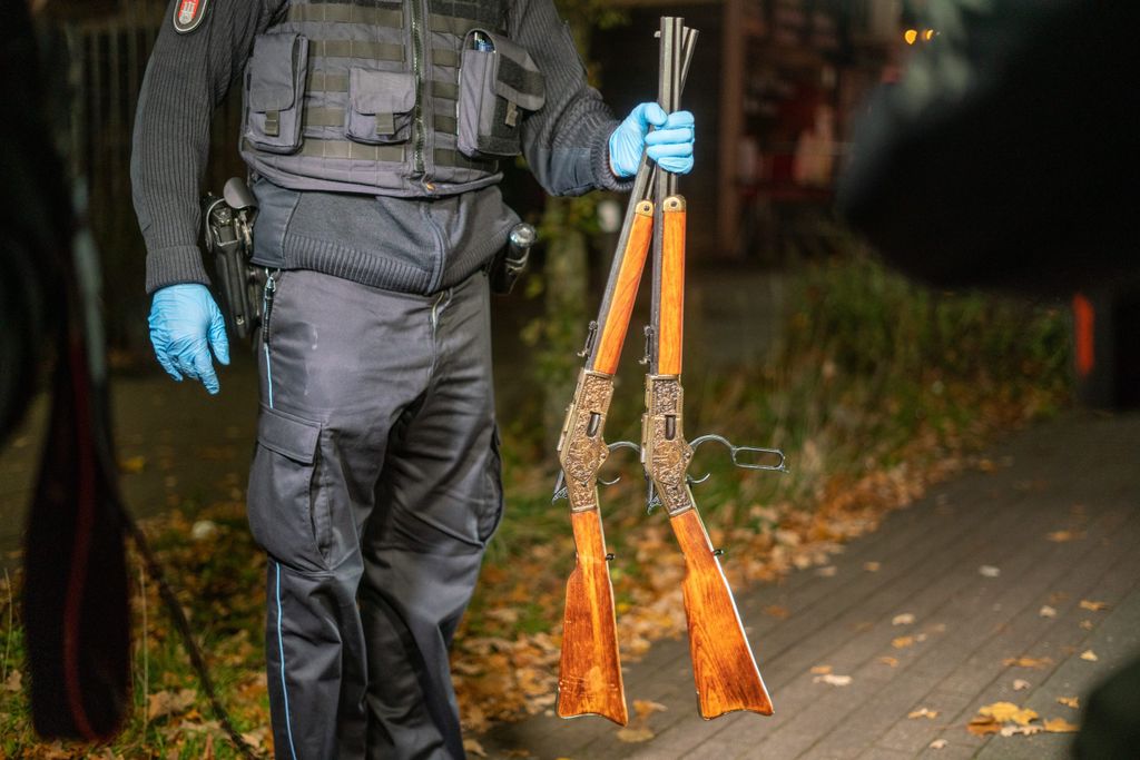 Ein Polizist mit den zwei sichergestellten Gewehren.