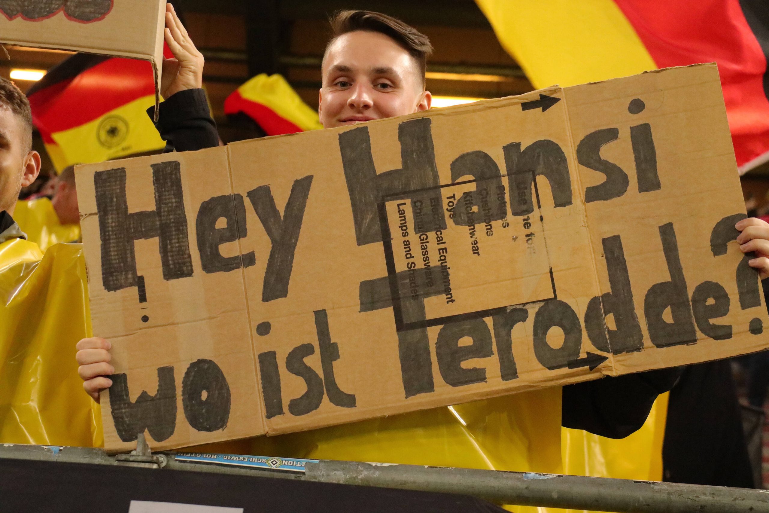 Deutschland-Fan mit Plakat mit der Aufschrift: „Hey Hansi, wo ist Terodde?“