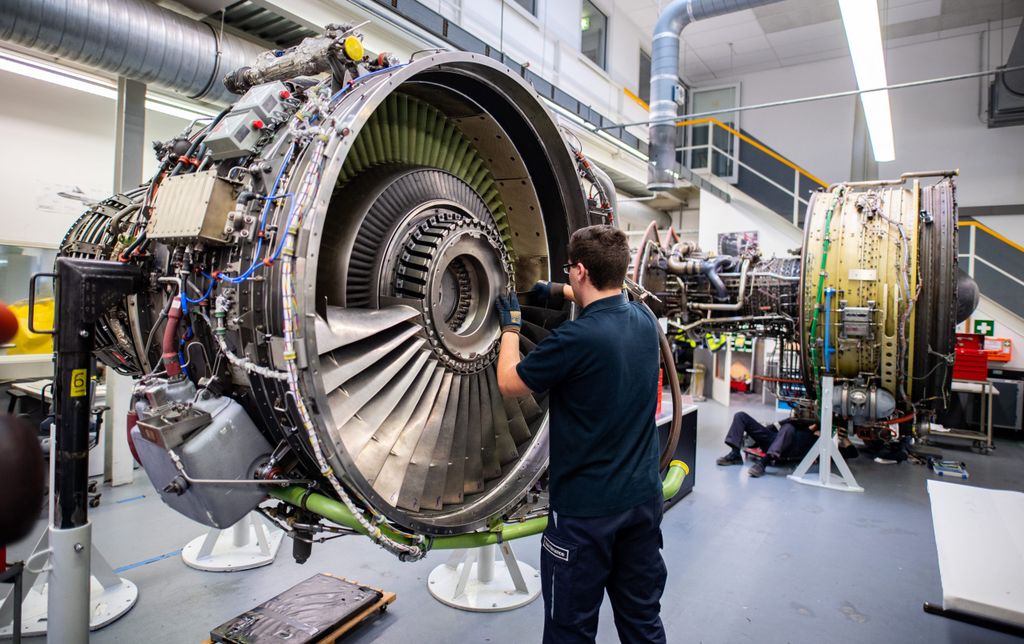 Ein Mitarbeiter von Lufthansa Technik am Triebwerk eines Flugzeuges.