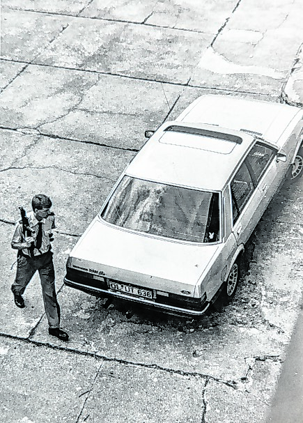 Ein Polizist mit Maschinenpistole sichert den aufgefundenen Fluchtwagen.