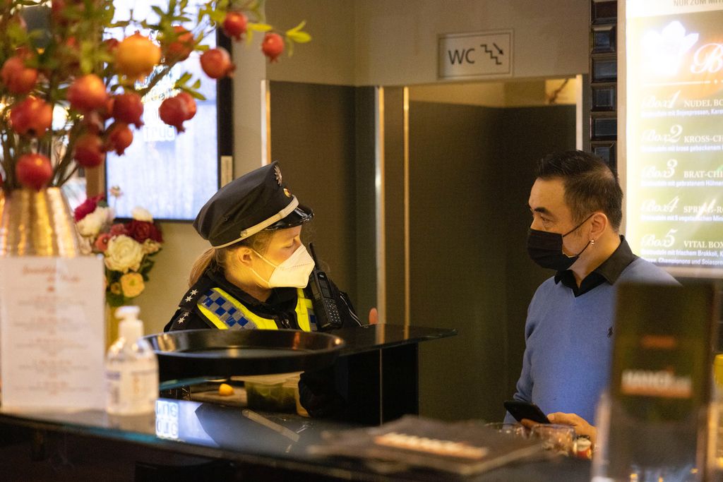Polizistin Stiena Jepsen im Gespräch mit einem Restaurant-Betreiber. Bei ihm hatten Gäste keinen gültigen Testnachweis.